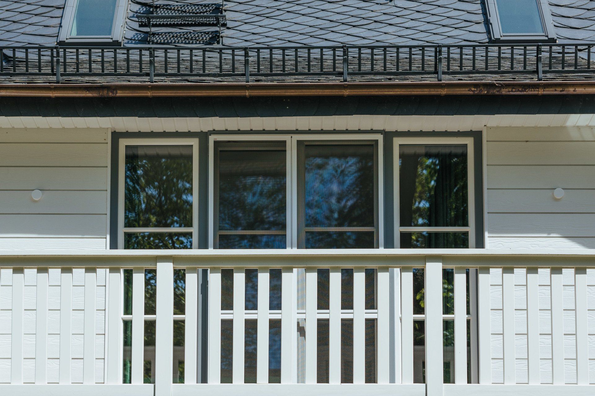 Ein Haus mit einem Balkon und einem Oberlicht auf dem Dach