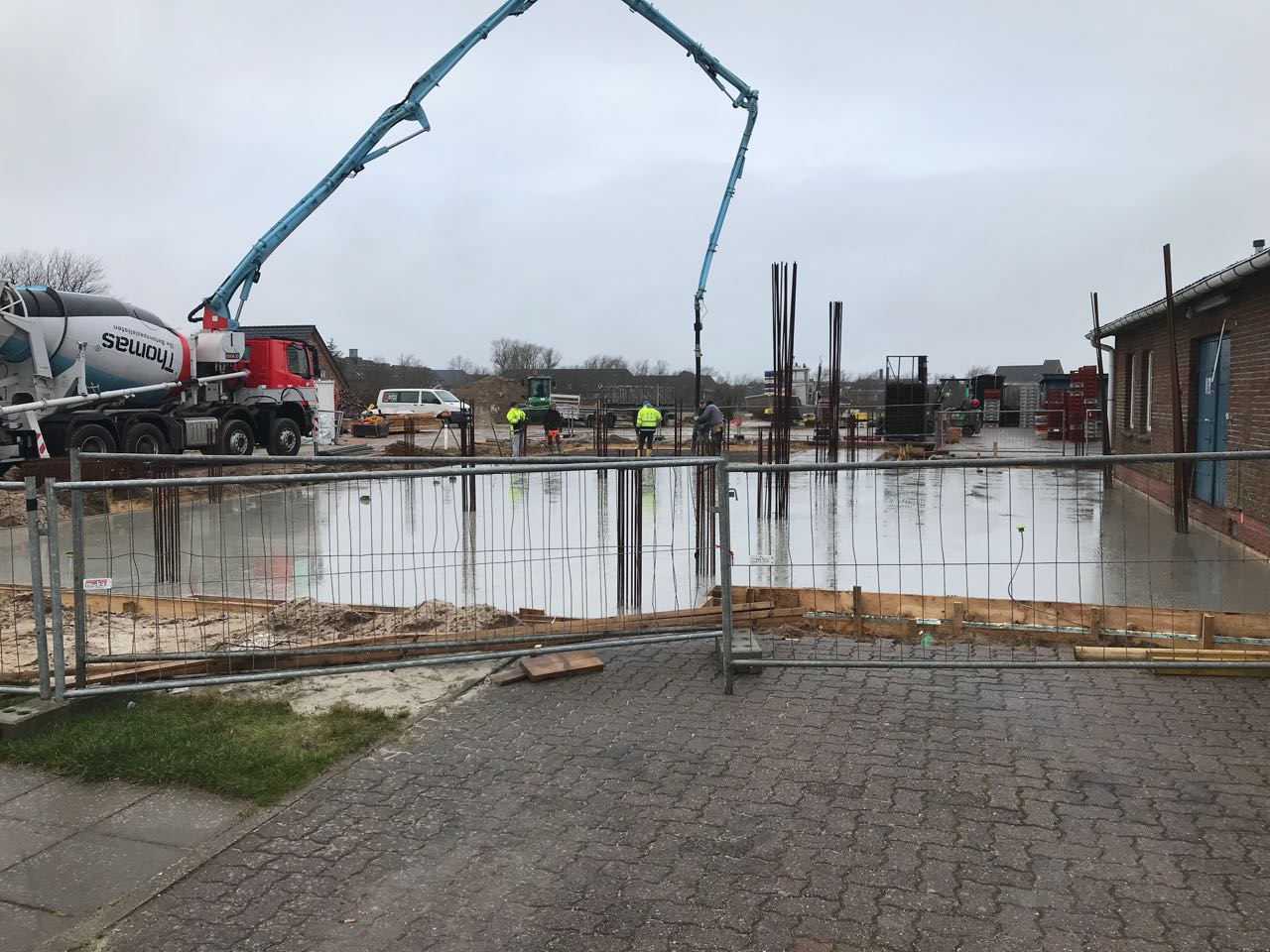 Auf einer Baustelle wird mit einer Betonpumpe Beton gegossen.