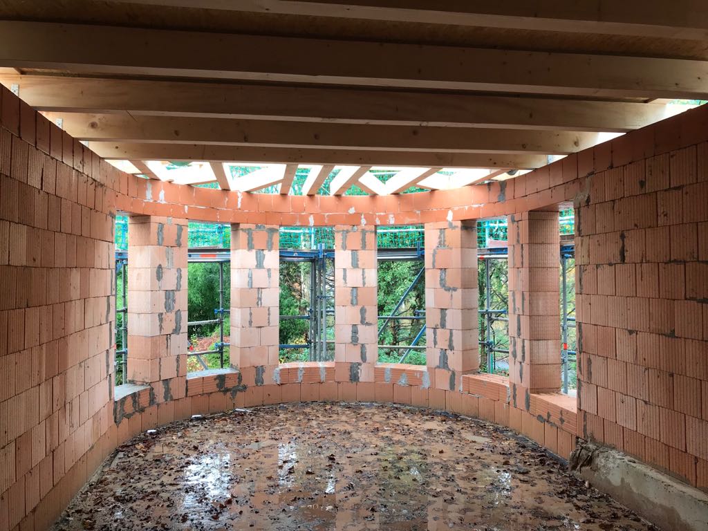 Ein im Bau befindliches Gebäude mit Ziegelwänden und Holzbalken.
