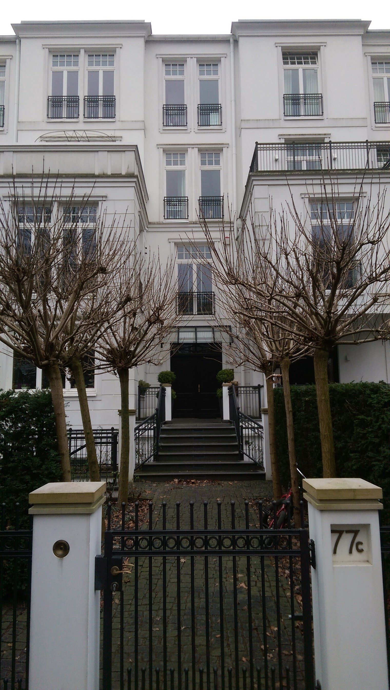 Ein großes weißes Gebäude mit einem schwarzen Tor davor