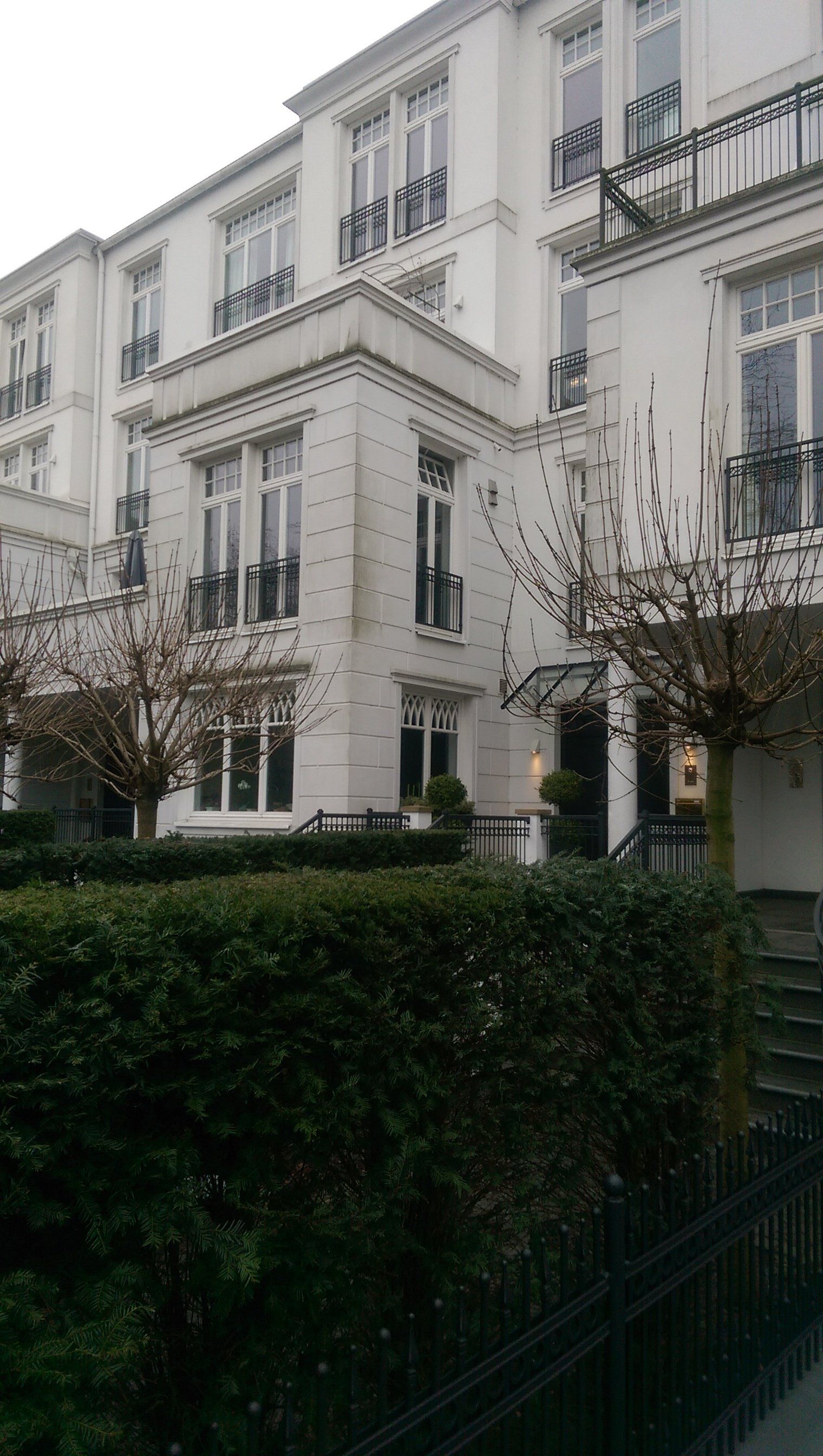 Ein großes weißes Gebäude mit einem Zaun davor.