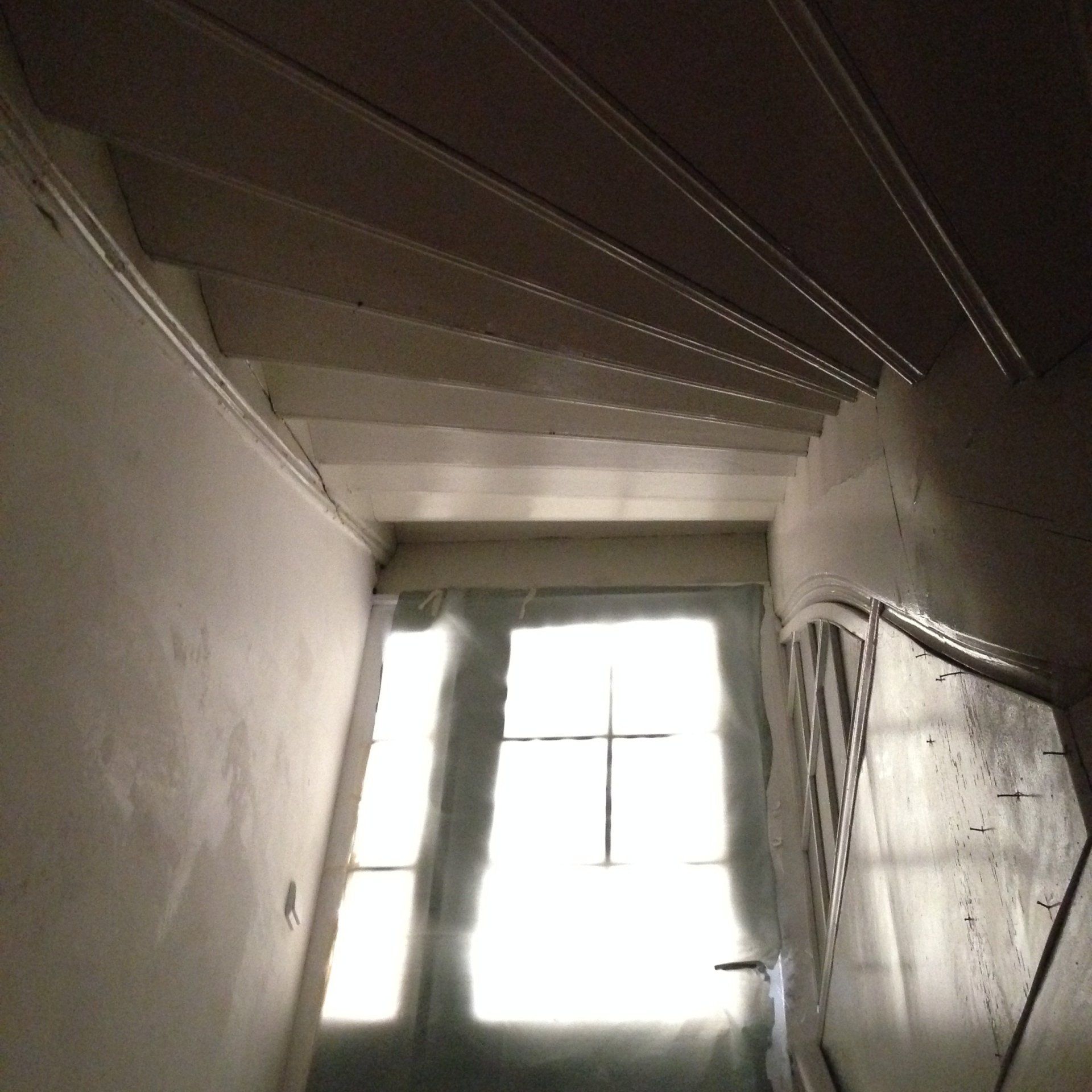 Treppe führt hinauf zu einer Tür mit einem Kreuz darauf