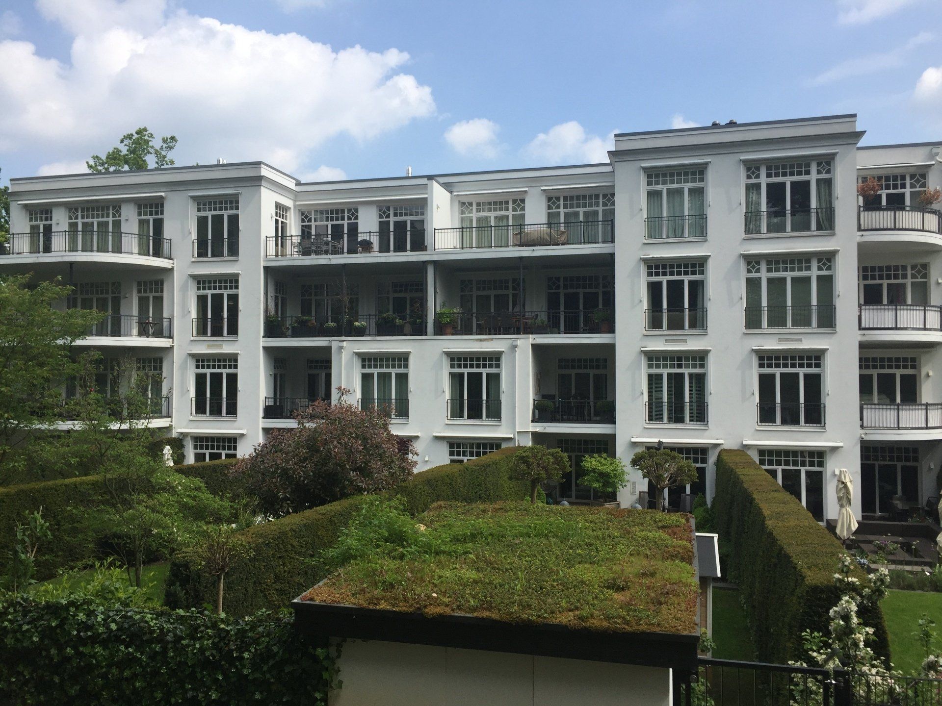 Ein großes weißes Wohnhaus mit einem grünen Dach
