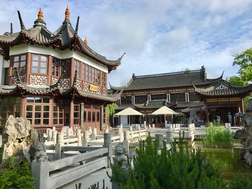 Ein chinesisches Gebäude mit einer Pagode und Sonnenschirmen davor