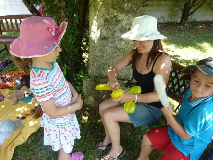 woman bending balloons for a young girl