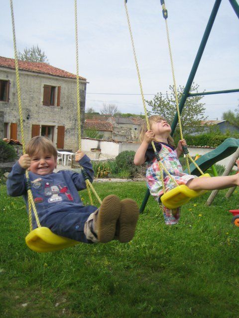 a boy and a girl swinging on swings