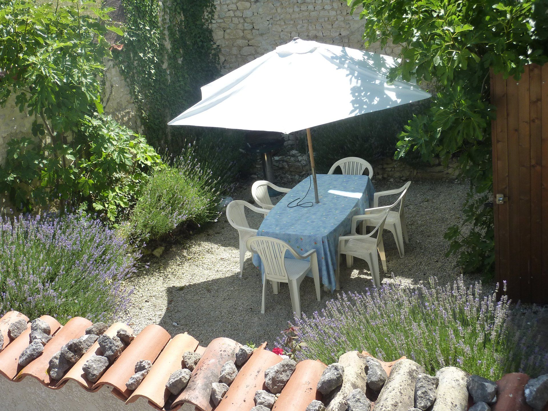 view of walled terrace from above looking down at plastic garden furniture
