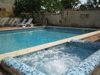 small jacuzzi style bubbling pool next to a swimming pool