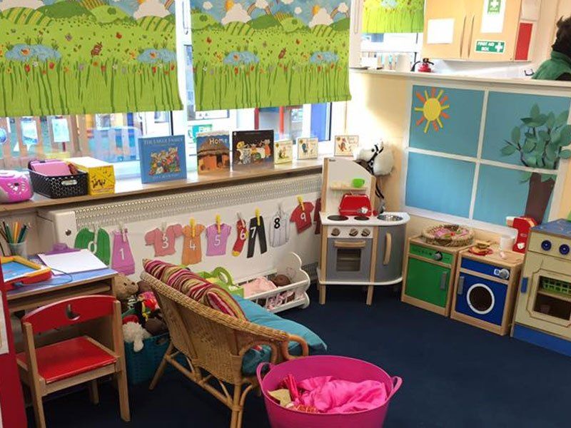 An indoor play area set up like a kitchen with wooden toy furniture