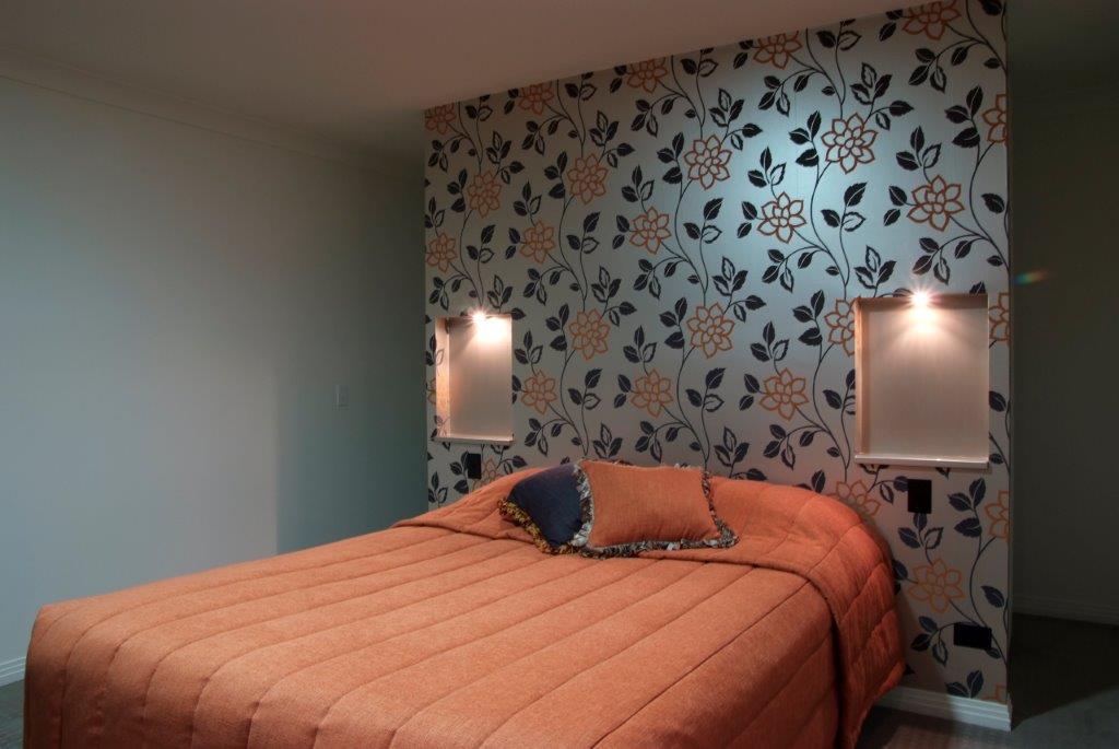 bed with floral wallpaper