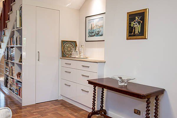 white cupboards with hallway table and paintings