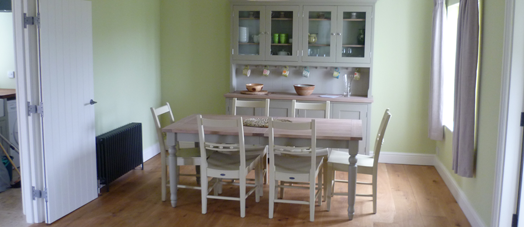 Dining table and 6 chairs in a room with a dresser in the background