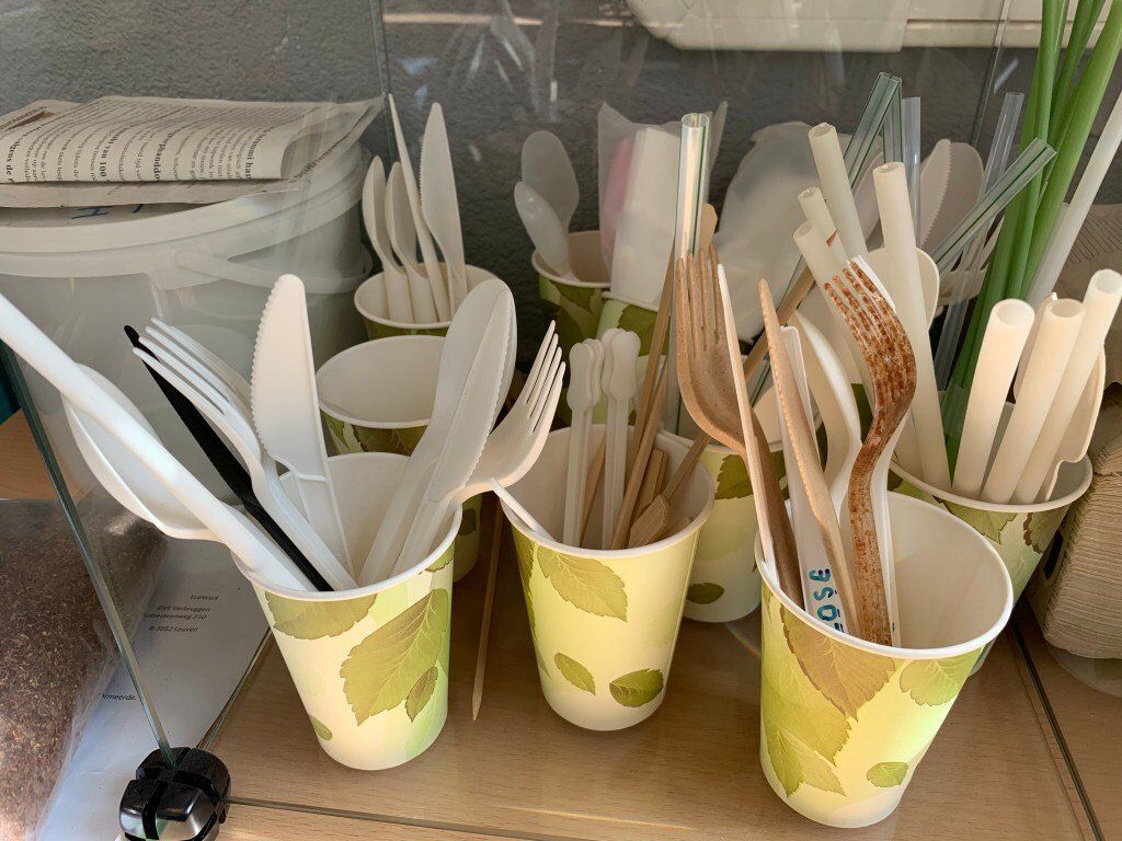 A table topped with paper cups and wooden utensils.