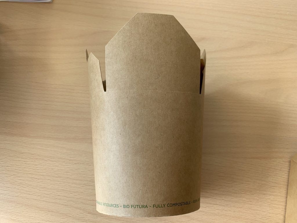 Cardboard packaging is sitting on a wooden table.