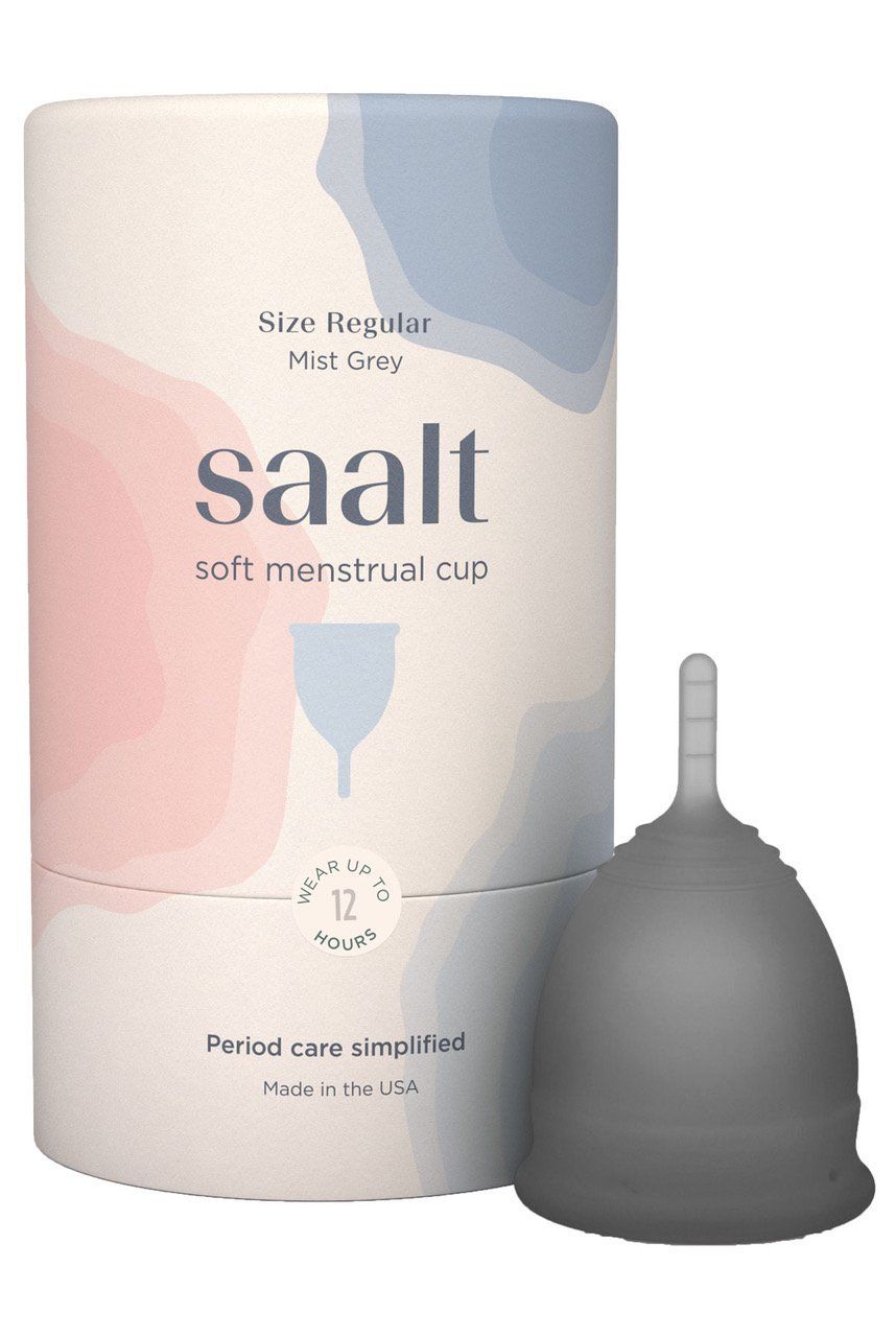 A gray menstrual cup is sitting next to a pink and blue box.