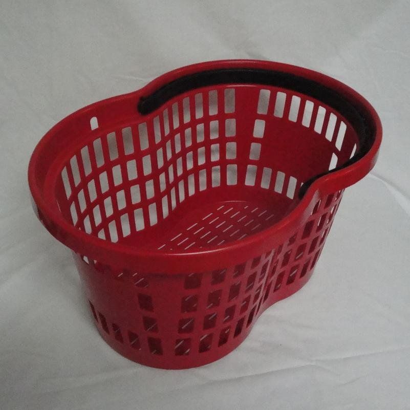 A red basket with a black handle sits on a white cloth