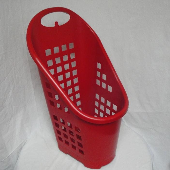 A red laundry basket is sitting on a white cloth