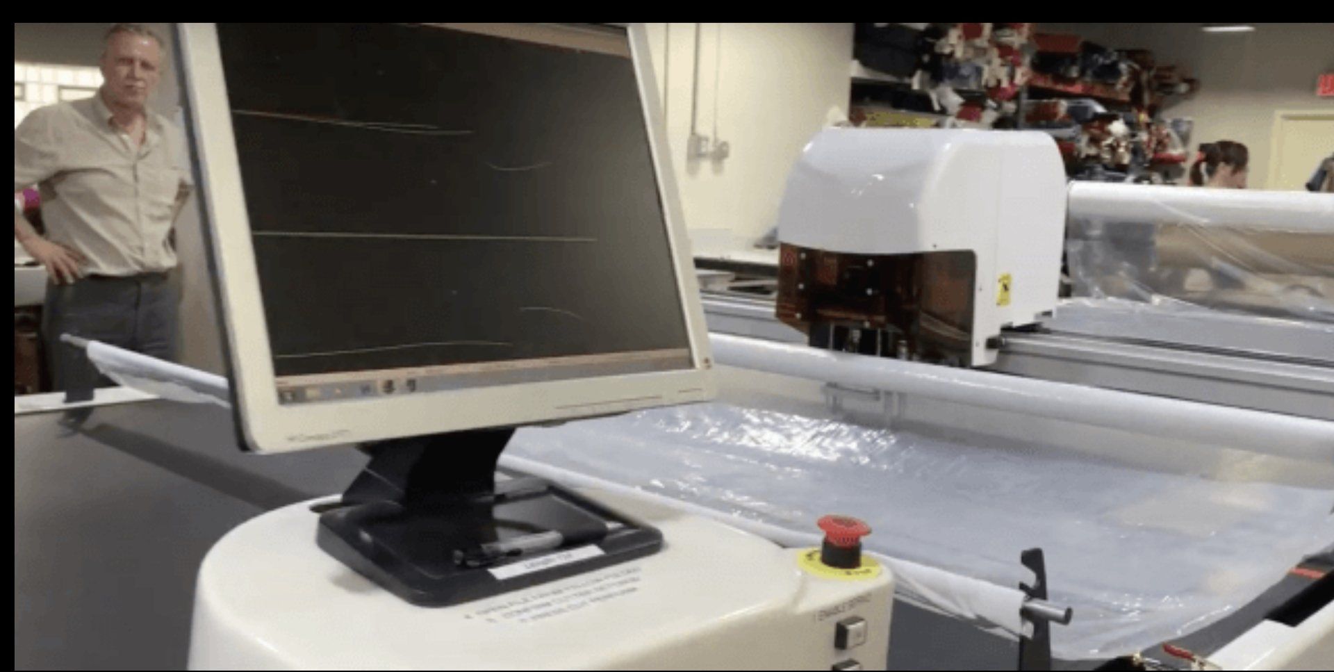 A computer monitor is sitting on top of a machine in a factory.