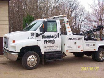 Tow truck towing a car — Peggan's Auto Body & Sandblasting, LLC in St. Stephen, MN Tow truck towing a car — Peggan's Auto Body & Sandblasting, LLC in St. Stephen, MN