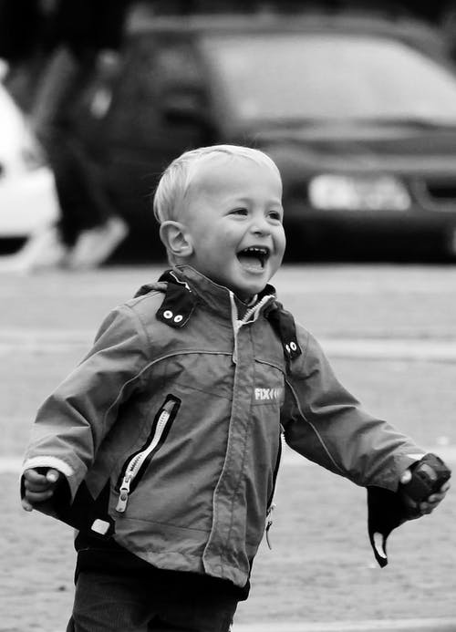 laughing boy toddler outdoors with jacket on