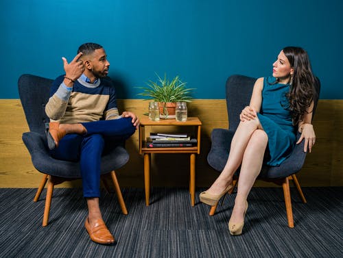 man and woman sitting looking at each other talking life