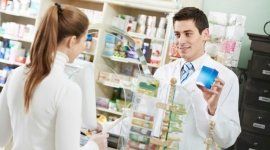 farmacista mostra un medicinale a una cliente