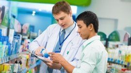colleghi farmacisti discutono in mezzo agli scaffali di una farmacia