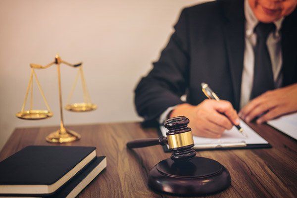 Law Firm — Gavel On Table And Lawyer Working With Agreement in Redding, CA Law Firm — Gavel On Table And Lawyer Working With Agreement in Redding, CA