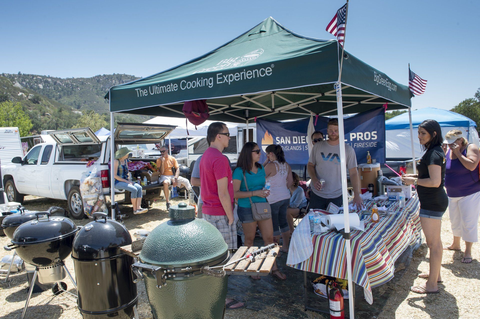 A group of people standing under a tent that says ultimate cooking experience