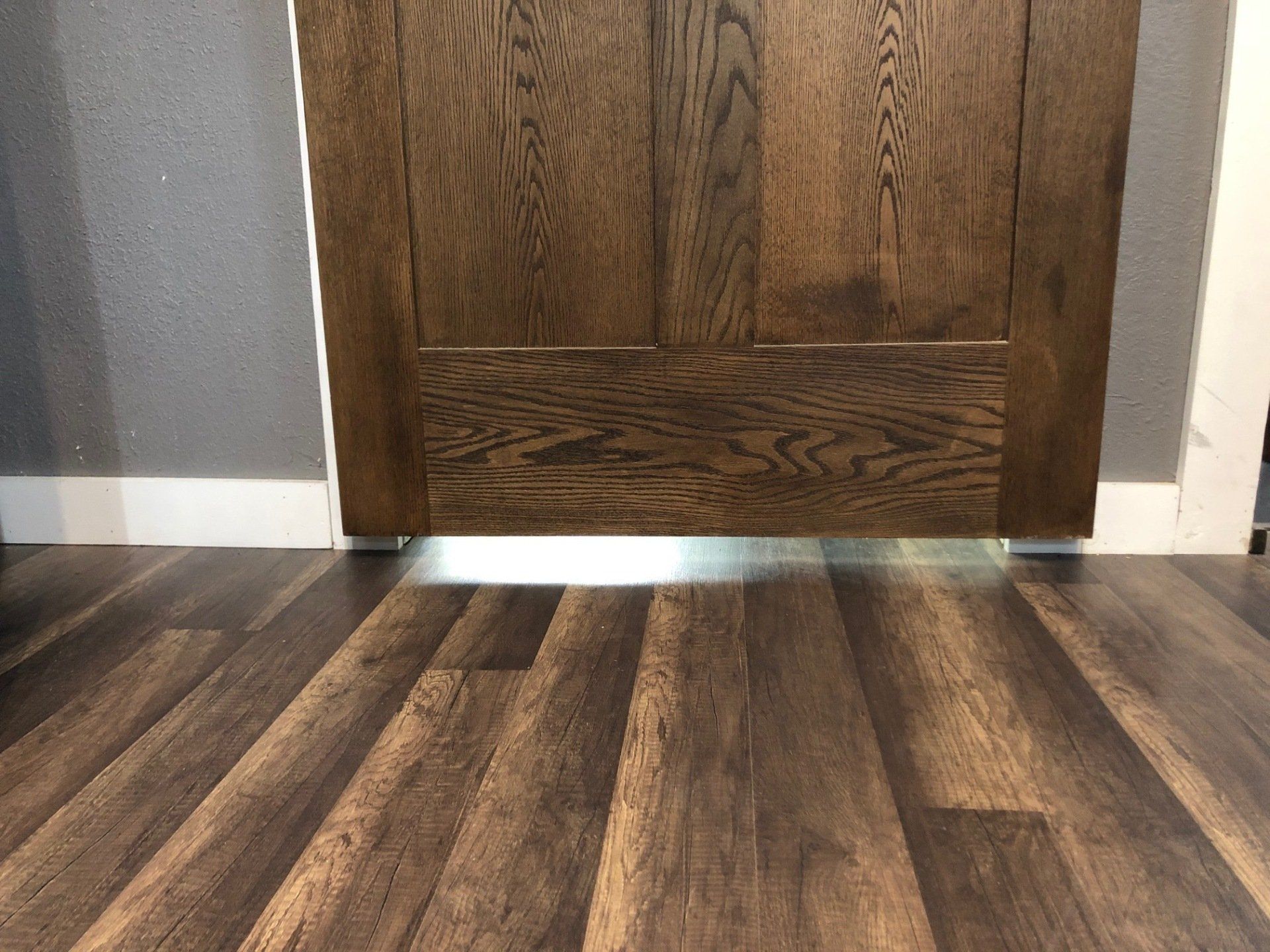 Dark flooring in front of a barn door | Commercial-Grade Flooring
