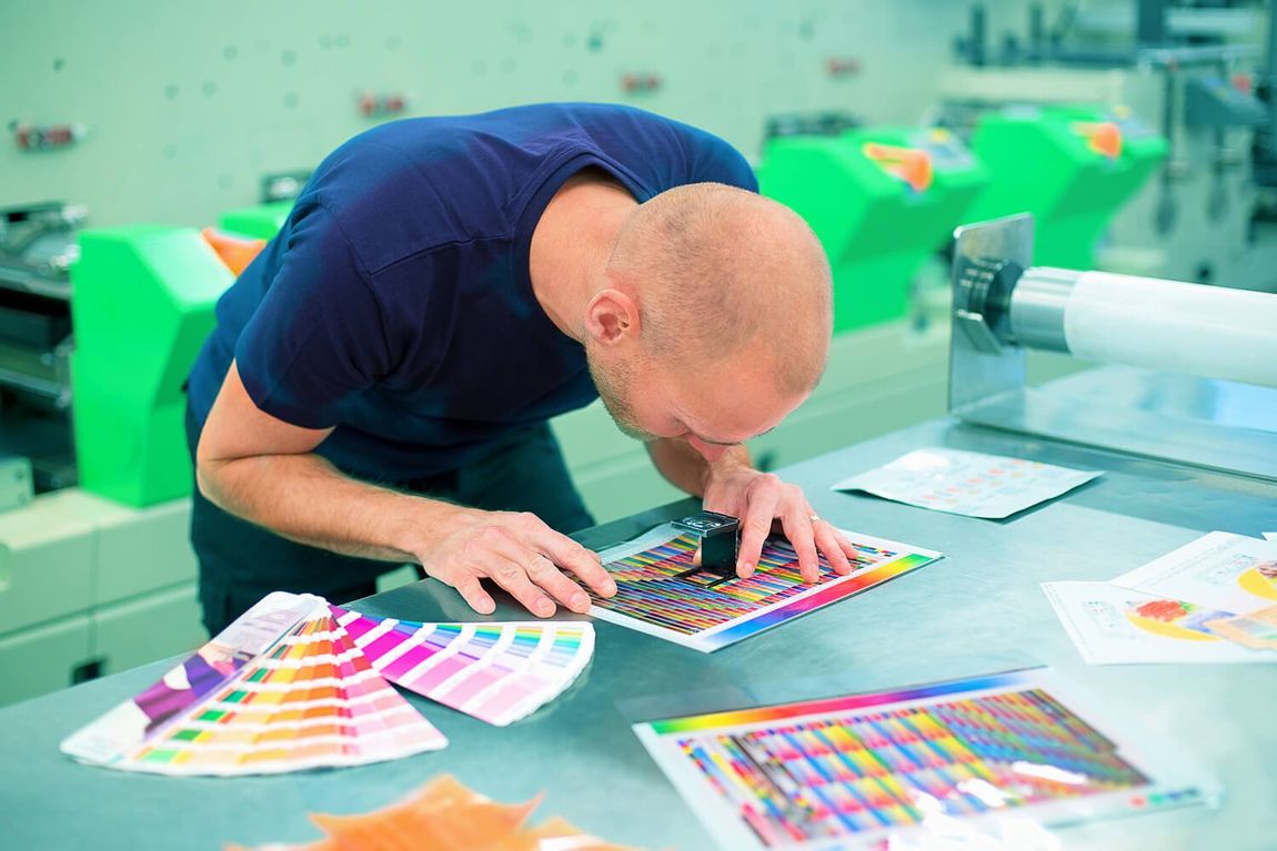 a man is looking at a piece of paper with a magnifying glass .