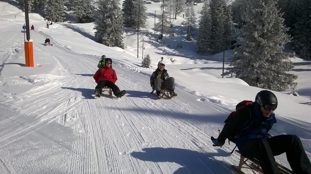 A group of people are sledding down a snowy hill.