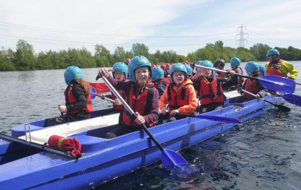 A group of people are rowing a boat on a lake.
