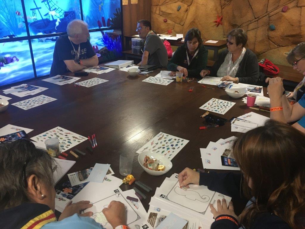 A group of people are sitting around a table with papers on it.