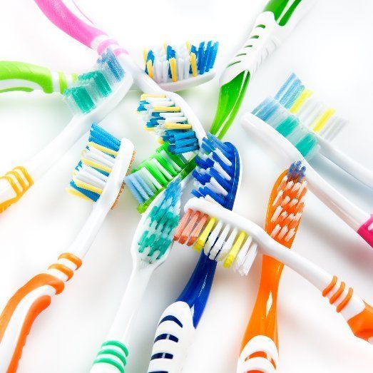 A bunch of colorful toothbrushes on a white surface