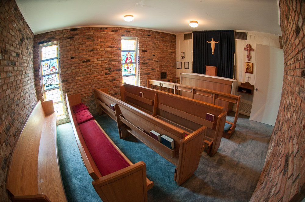 The Episcopal Church of the Redeemer Chapel with a stained glass window and a cross