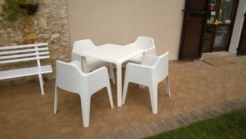 tavolo bianco con sedie in plastica
