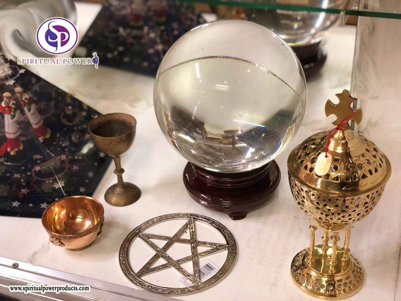 Een kristallen bol zit op een tafel naast een pentagram.