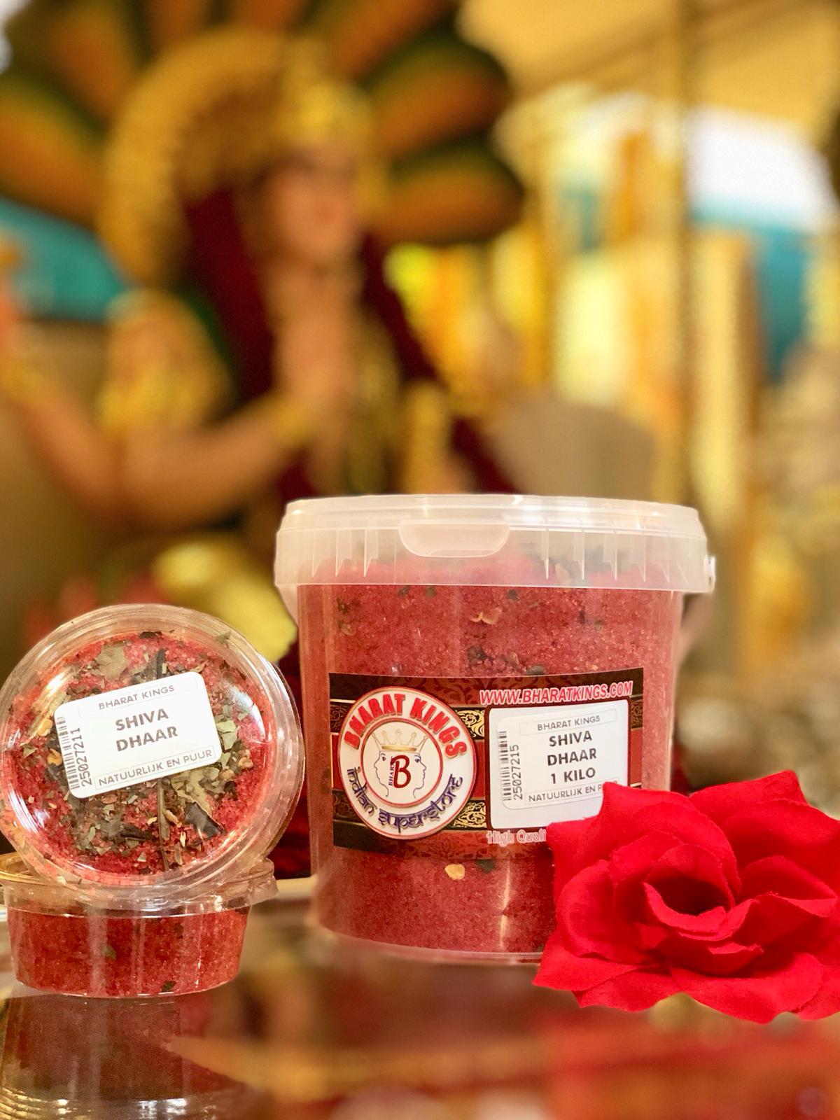Naast een rode roos staan ​​twee containers met rood poeder.