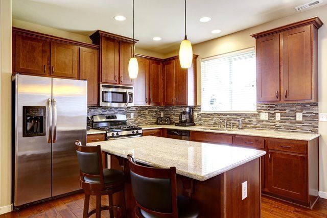 A kitchen with stainless steel appliances and wooden cabinets.