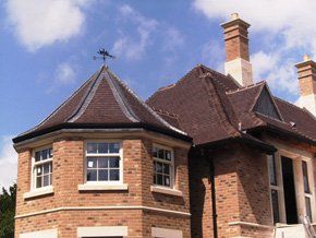 A red brick house with dark red tiling