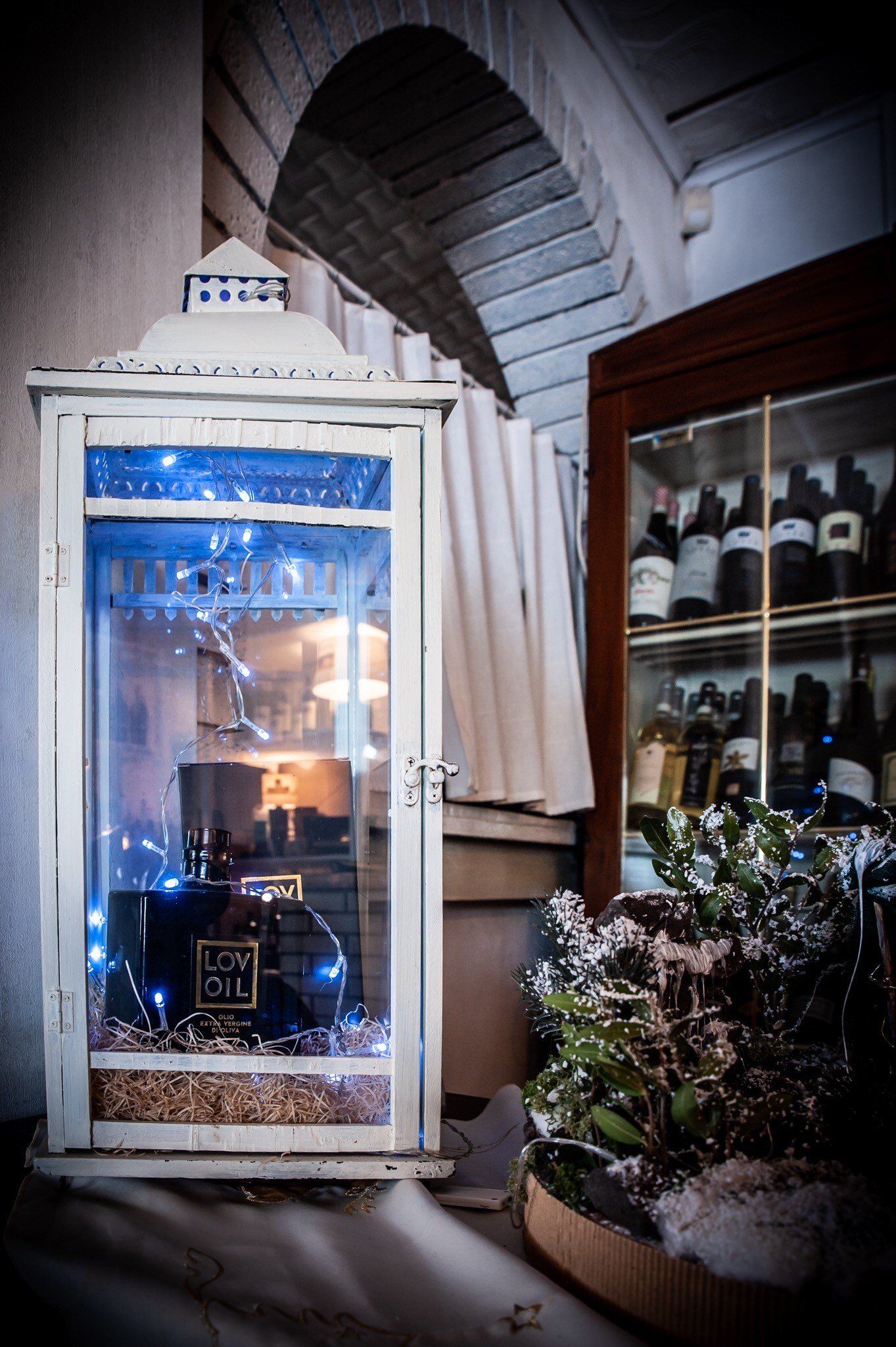 Una lanterna è posta davanti a una vetrina di bottiglie di vino.