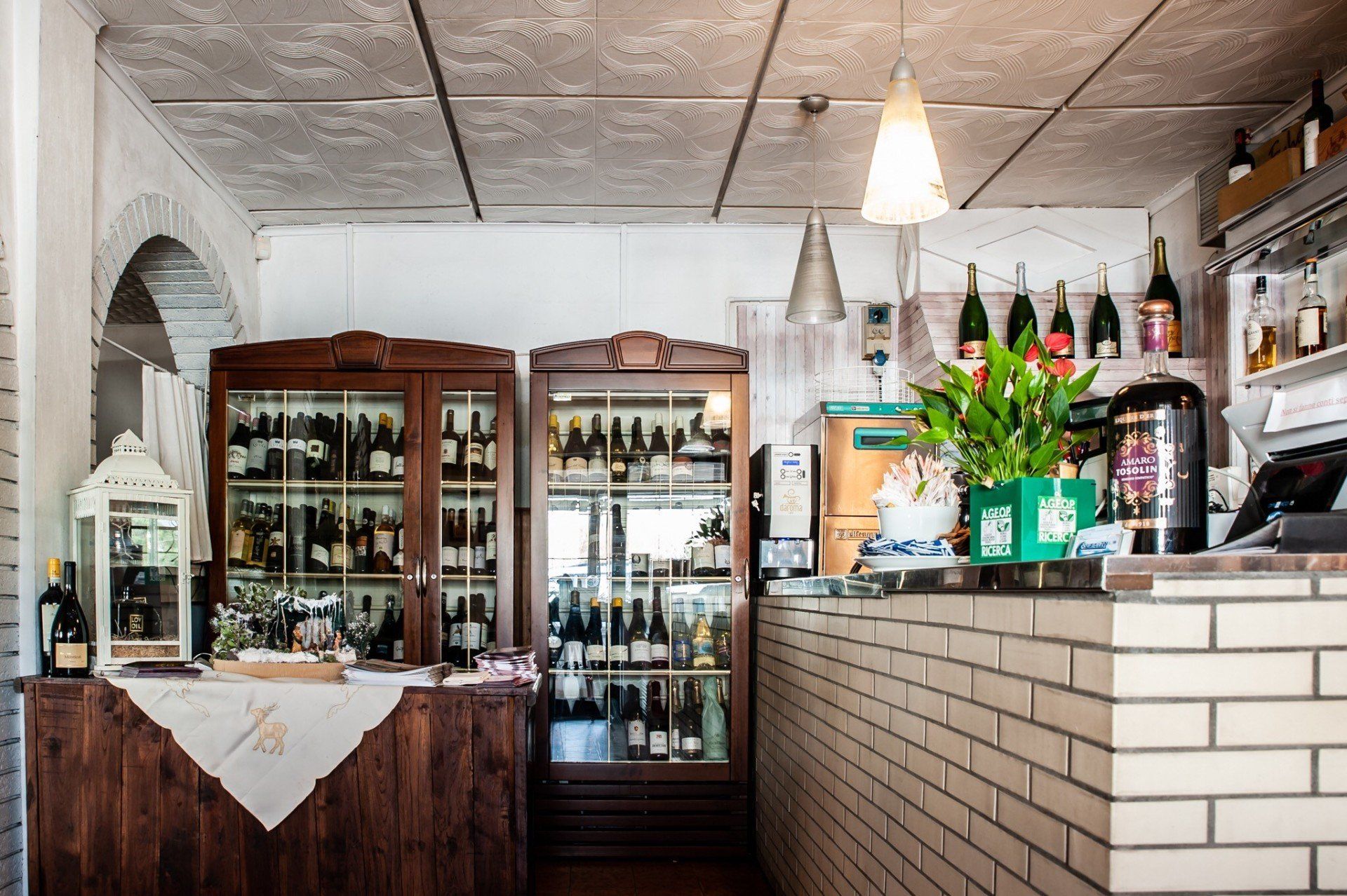 Un bar con un muro di mattoni e un frigorifero pieno di bottiglie di vino