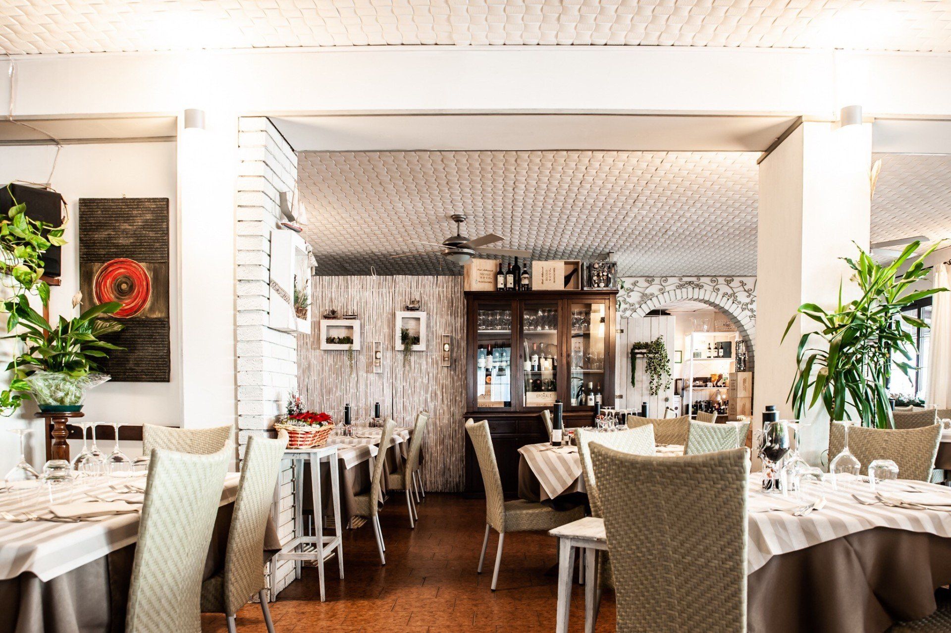 Un ristorante con tavoli, sedie e ventilatore a soffitto.