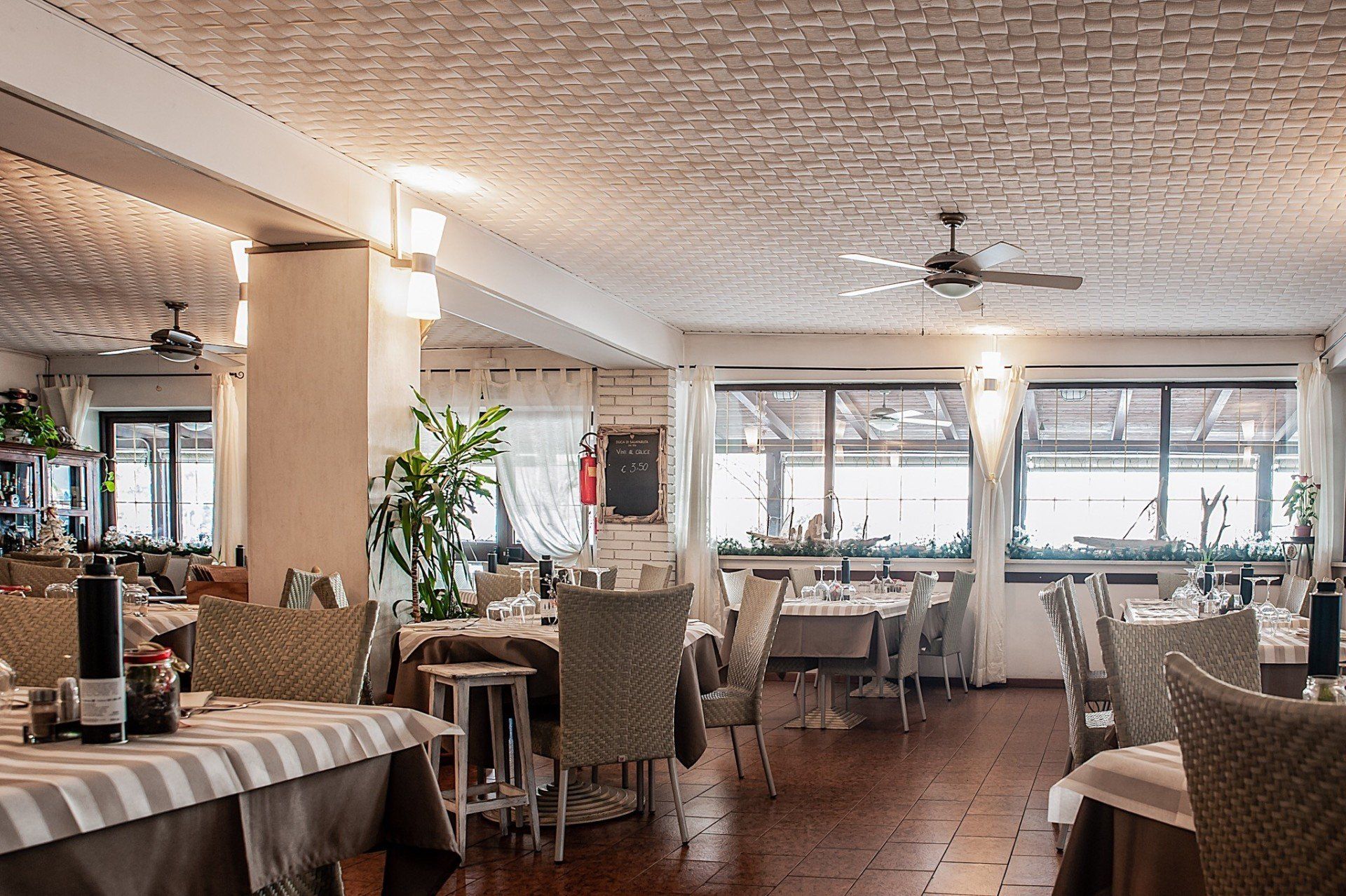 Un ristorante con tavoli e sedie e un ventilatore a soffitto