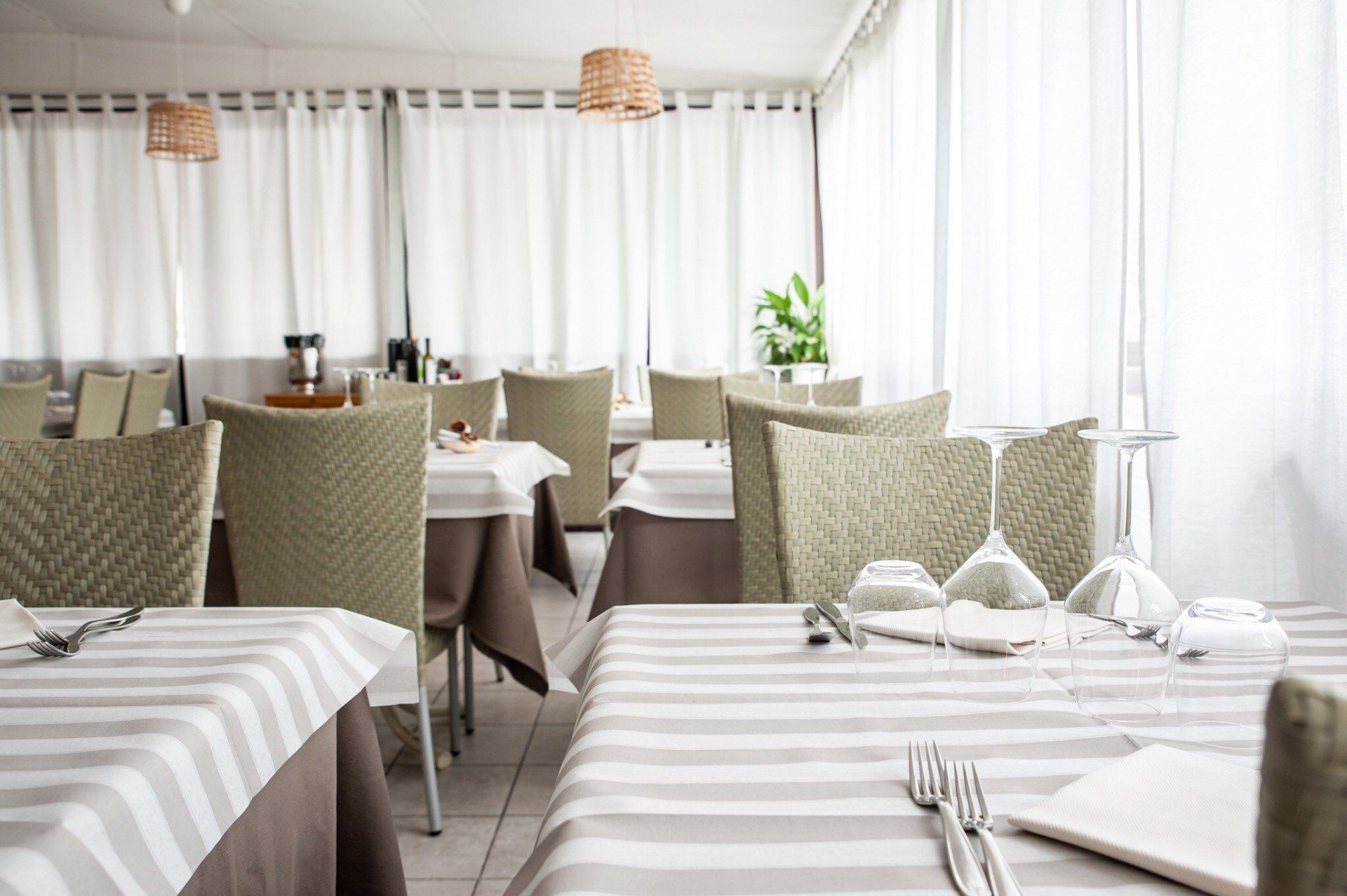 Un ristorante con tavoli e sedie e una tovaglia a righe
