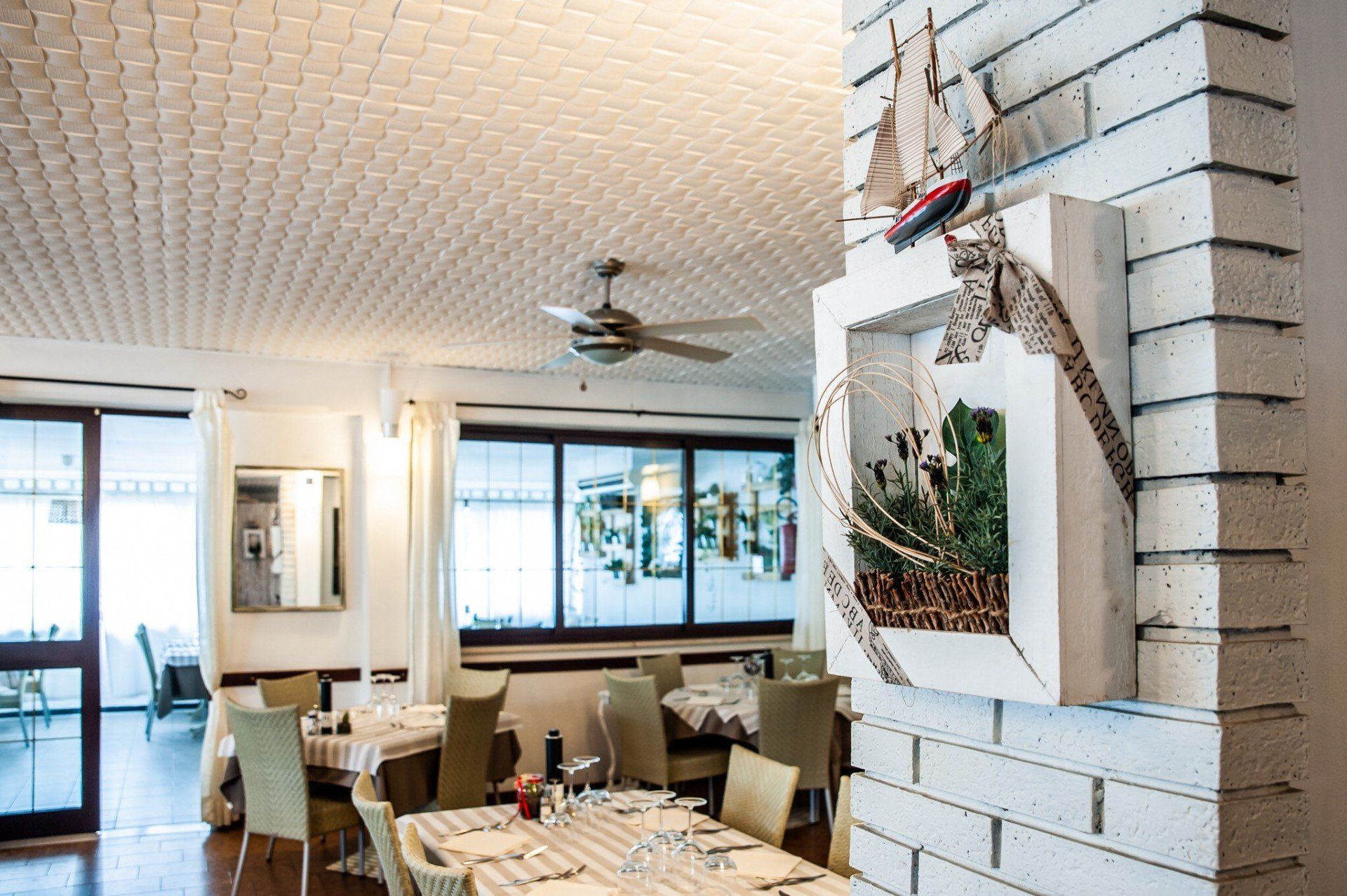 Un ristorante con tavoli e sedie e un ventilatore a soffitto