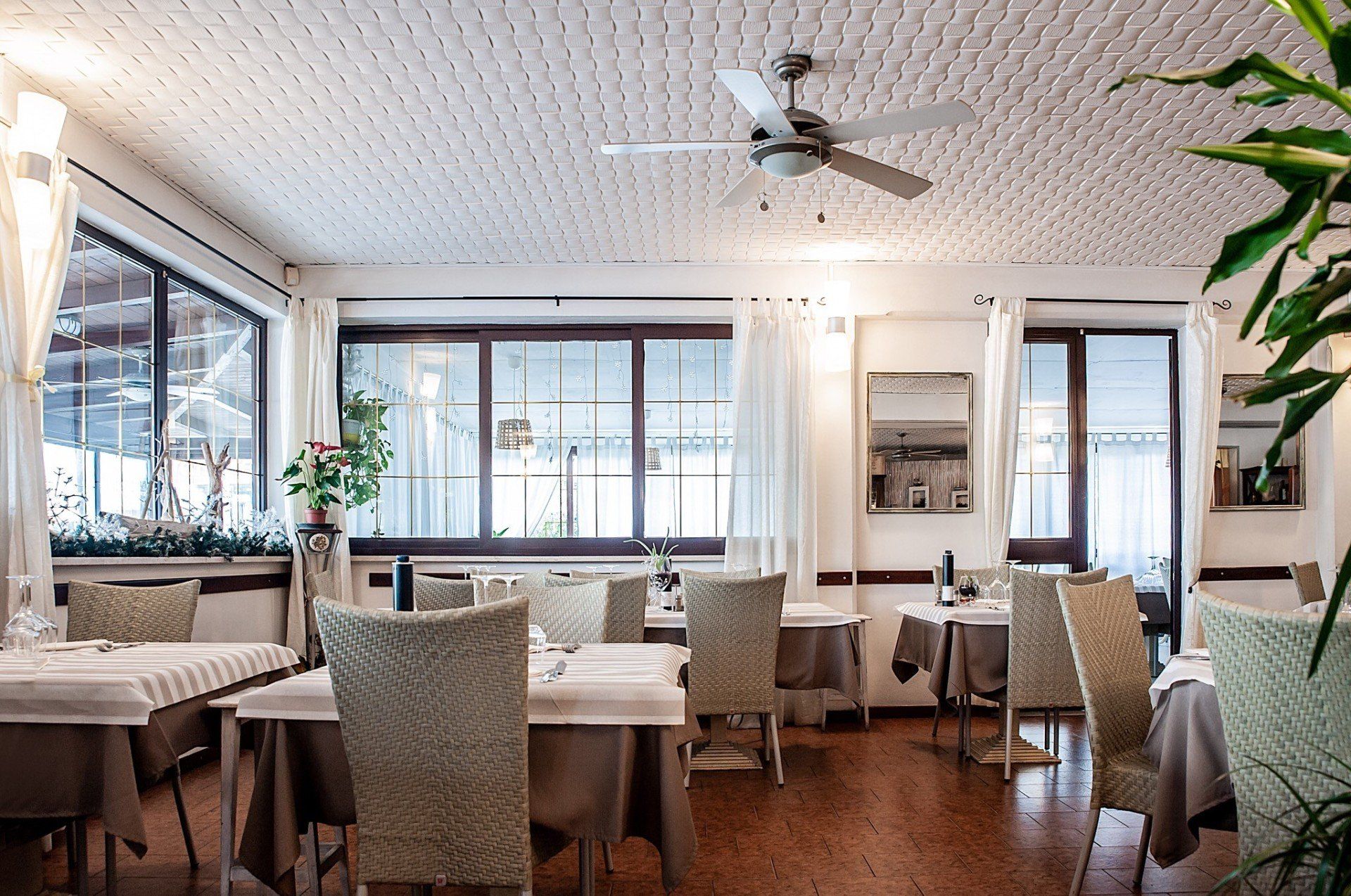 Un ristorante con tavoli e sedie e un ventilatore a soffitto