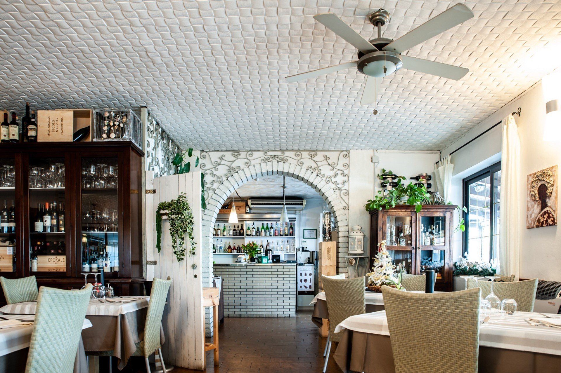 Un ristorante con tavoli e sedie e un ventilatore a soffitto