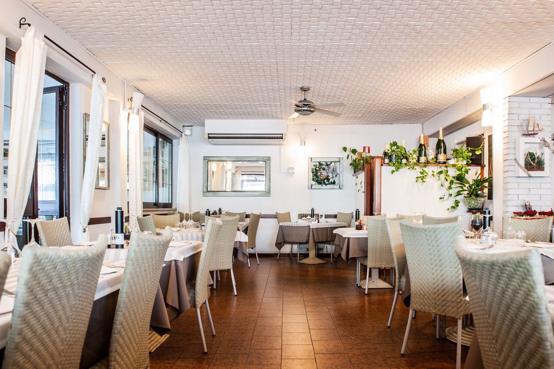 Un ristorante con tavoli e sedie e un ventilatore a soffitto